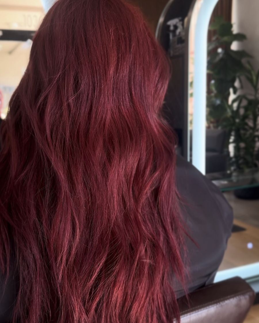Rich burgundy red color with loose waves at Ra'pôr Salon in Costa Mesa